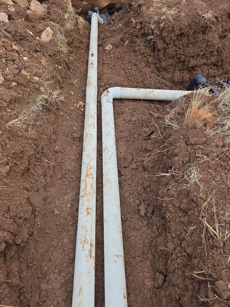 PVC pipes installed in a trench for drainage or plumbing purposes.